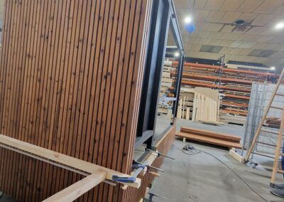 Revestimiento de madera colocado sobre estructura metálica en cocina exterior.
